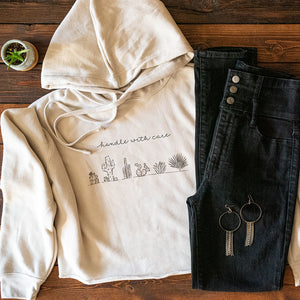 Cropped Hoodie with cacti design and "handle with care" lettering on front. Comfy and stylish hoodie.